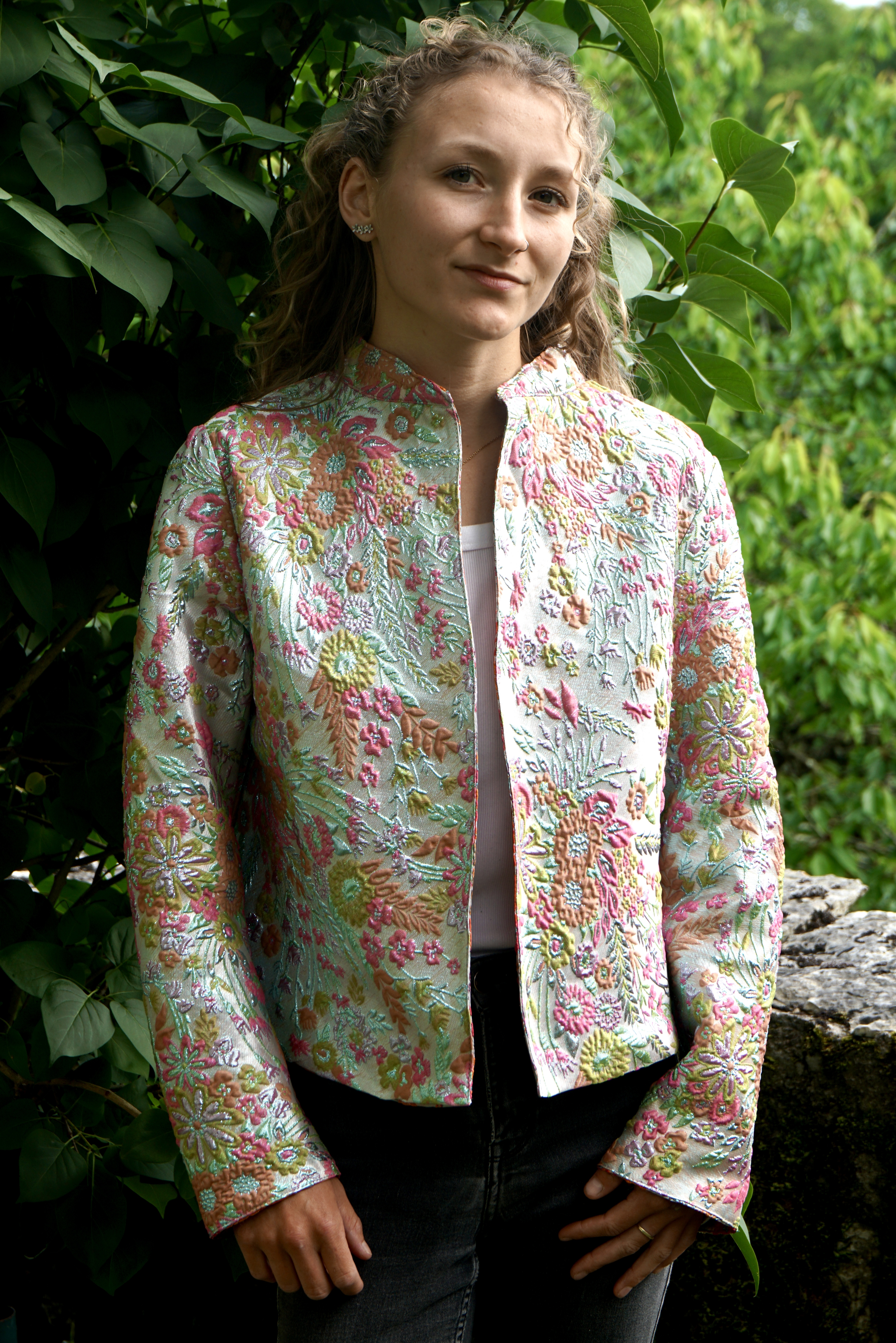 A short long sleeved jacket in pale colours and silver thread