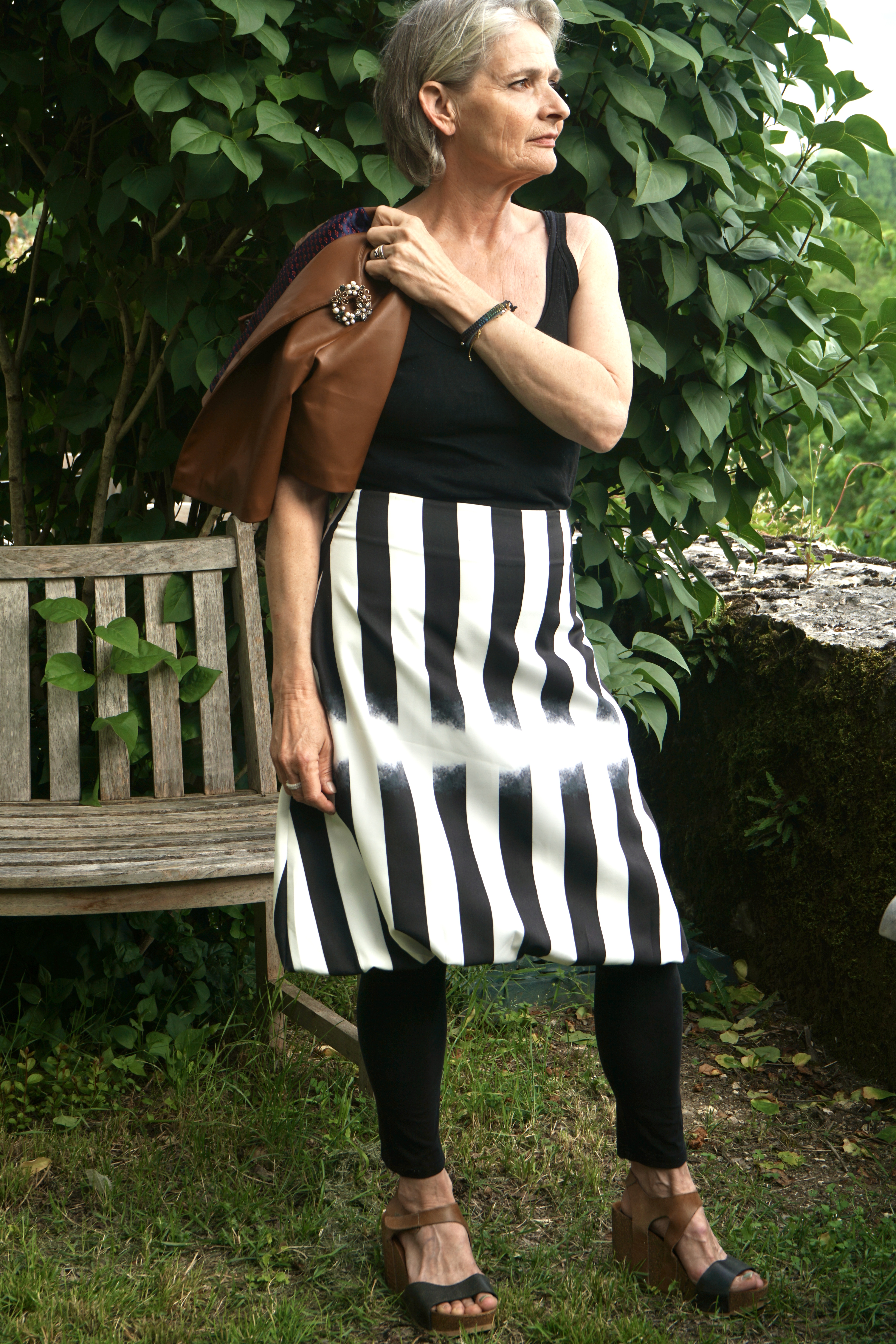 Model in striped black and white skirt, jacket on shoulder