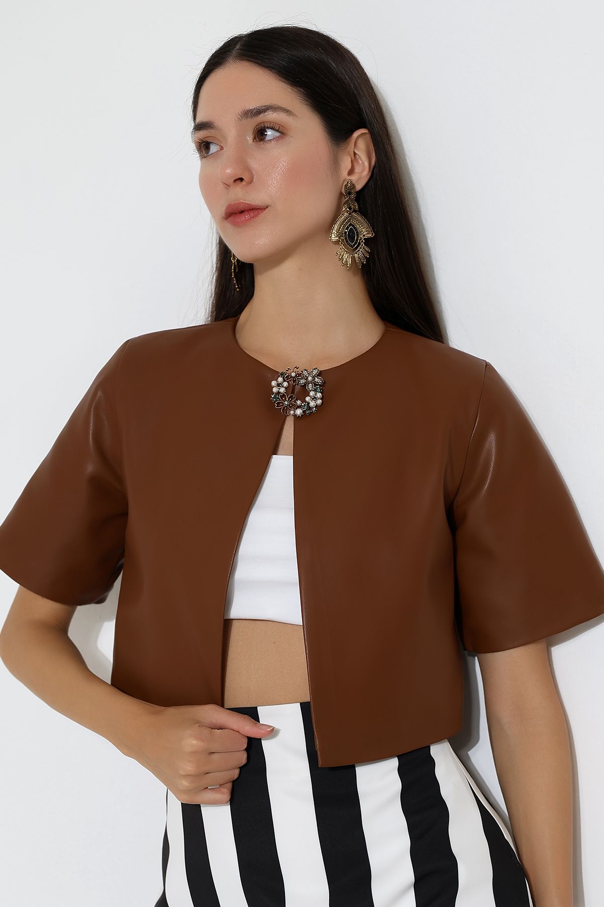 Model close up tan leather short sleeved jacket