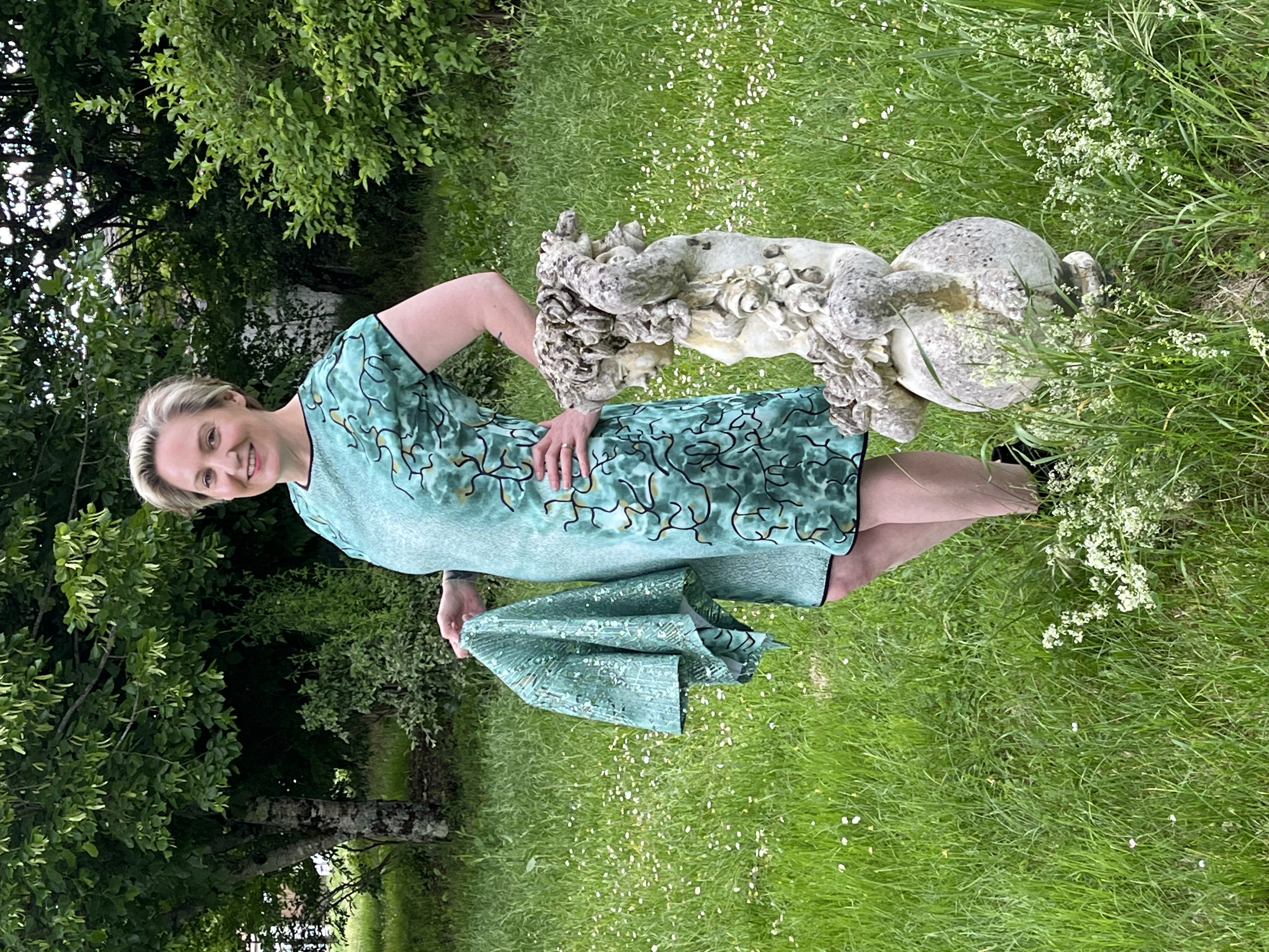 Full view outside near statue of short green evening dress and bolero