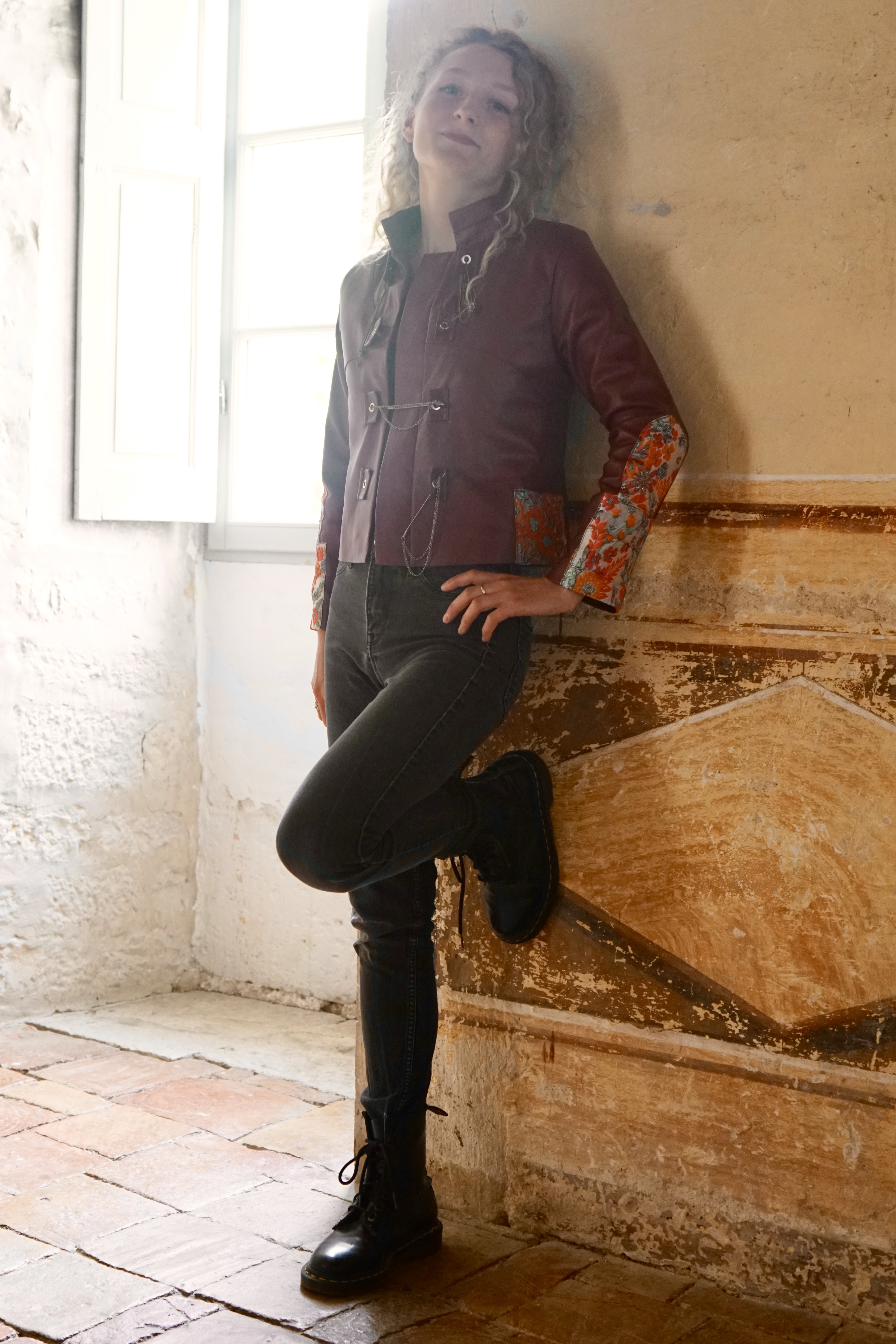Fullview model against wall showing leather jacket from distance